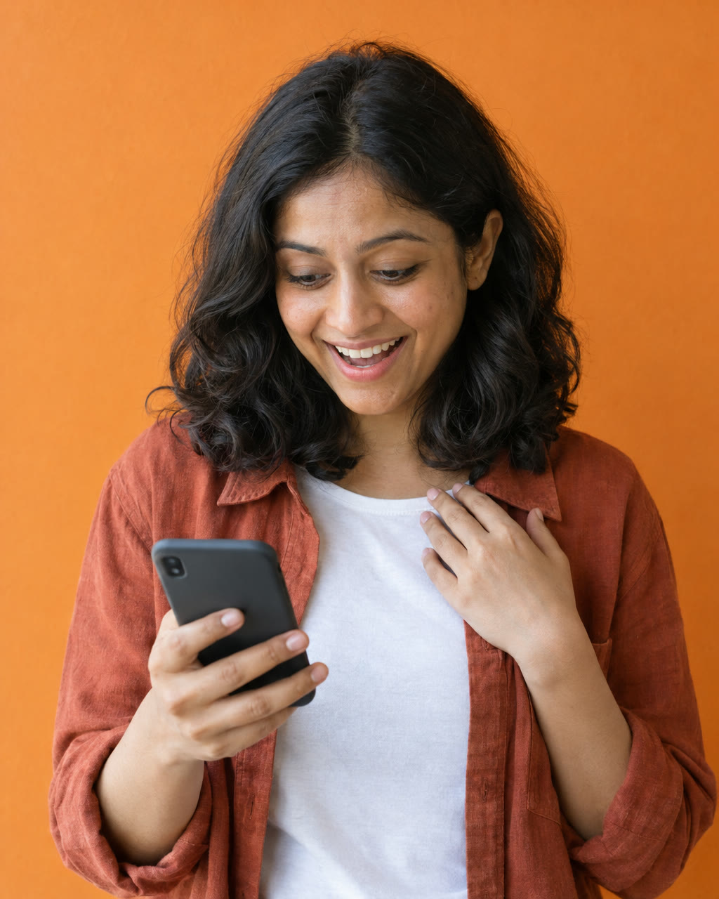 Woman reads good news on her phone and smiles